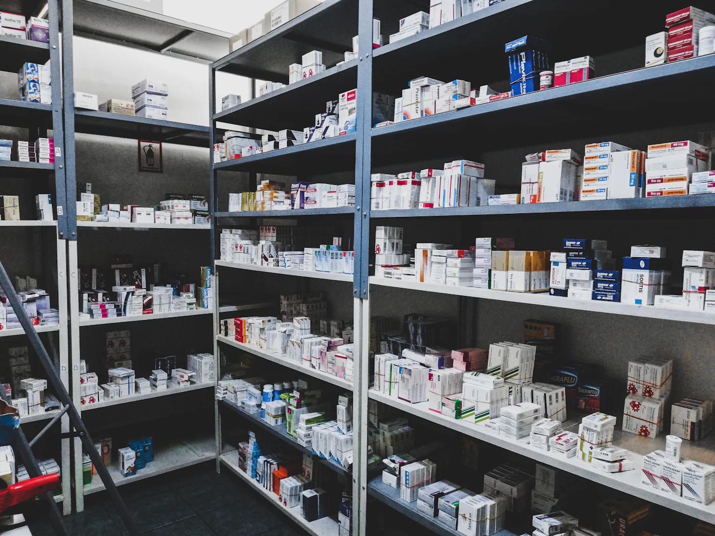 Well-organised pharmacy shelves stocked with medicines